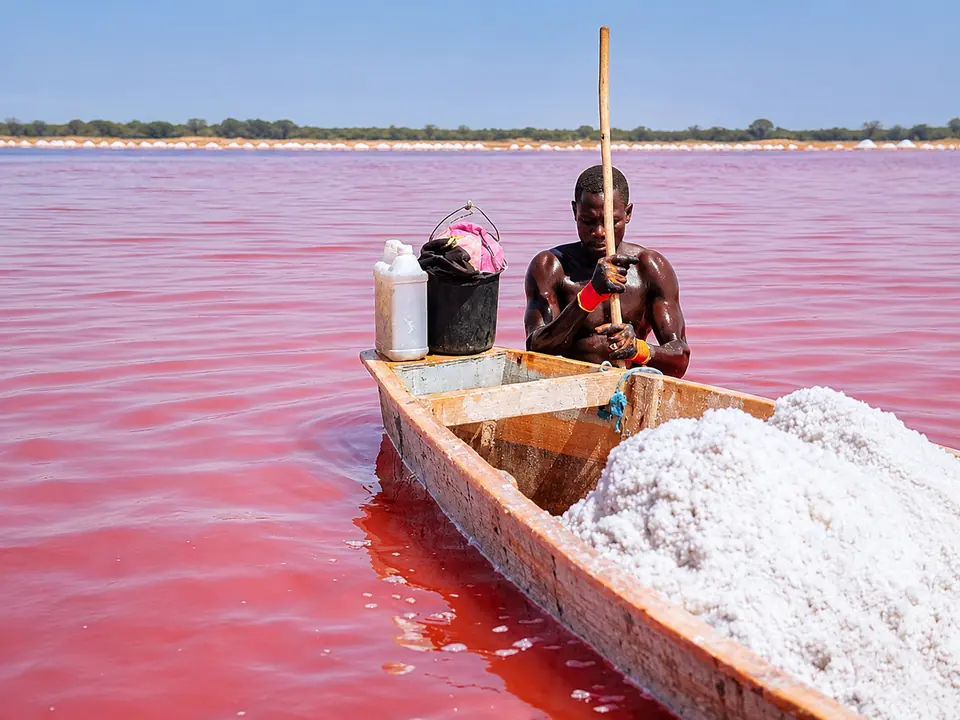 Pirogue et récolte de sel sur les eaux roses du Lac Retba